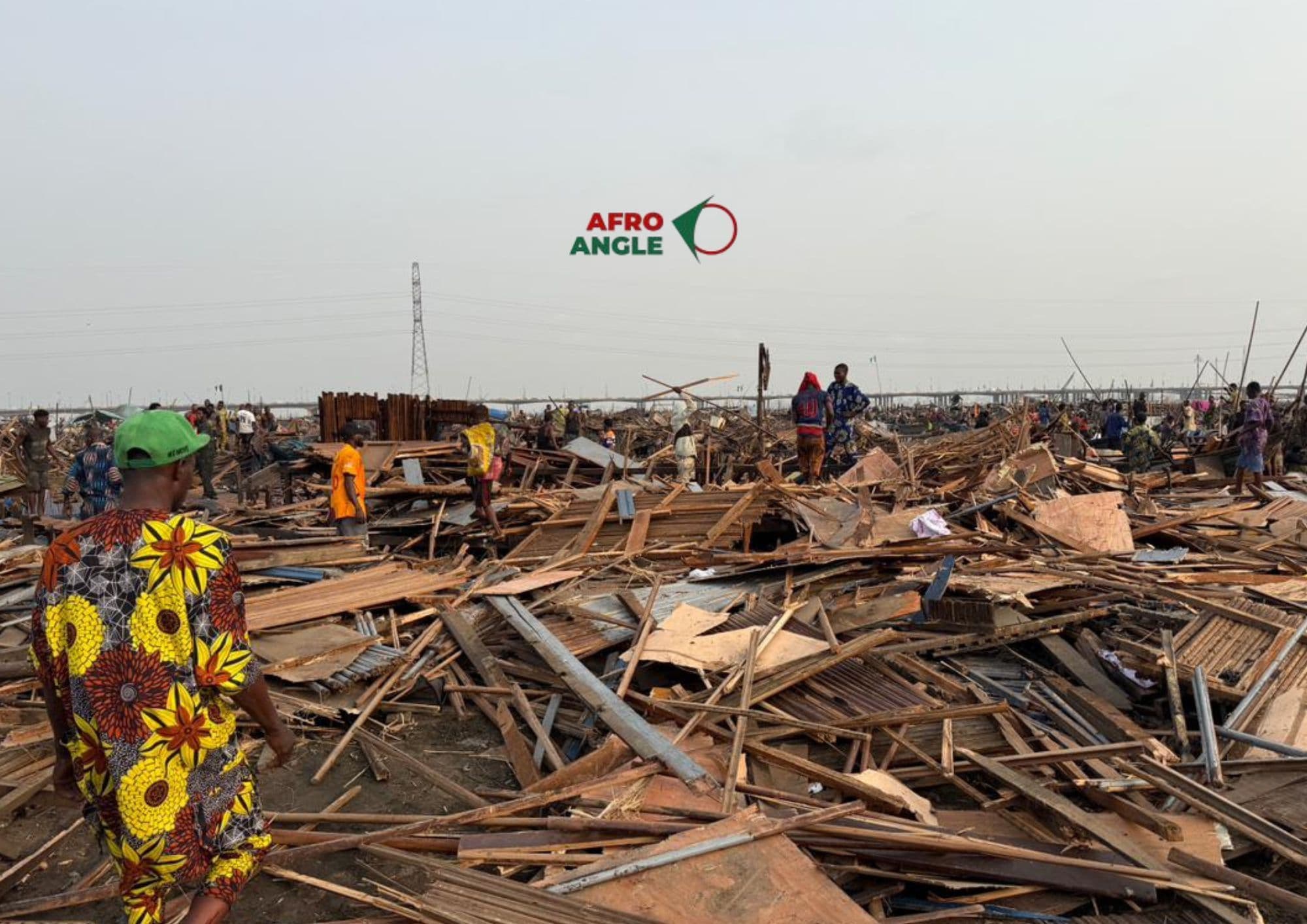 Makoko residents walk through the ruins left by the demolition